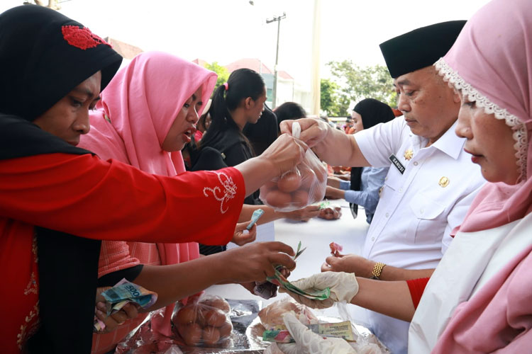 Bupati Malang, HM Sanusi, ikut membagikan telur ayam yang dijual di Operasi Pasar Murah kepada warga, di Kecamatan Dampit Kabupaten Malang, Kamis (4/4/2024). (Foto Humas Prokopim) 