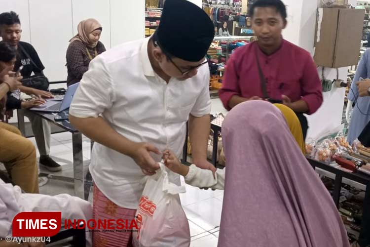 Kades Sidomulyo Kamiludin mendampingi anak yatim belanja baju lebaran gratis. (M. Abdul Basid/TIMES Indonesia)