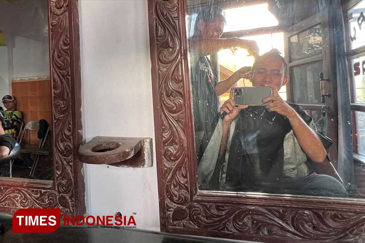 Husen Jehra saat melayani pelanggan. (Foto: Ryan H/TIMES Indonesia)