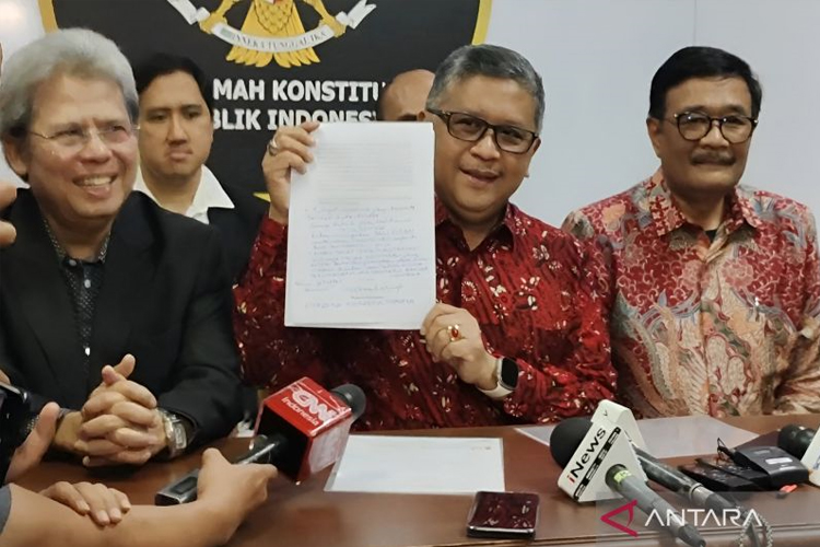 Sekretaris Jenderal PDI Perjuangan Hasto Kristiyanto (tengah) menunjukkan tulisan tangan Megawati dalam surat Amicus Curiae yang disampaikan oleh Megawati Soekarnoputri di Gedung II Mahkamah Konstitusi, Jakarta, Selasa (16/4/2024). (ANTARA/Nadia Putr