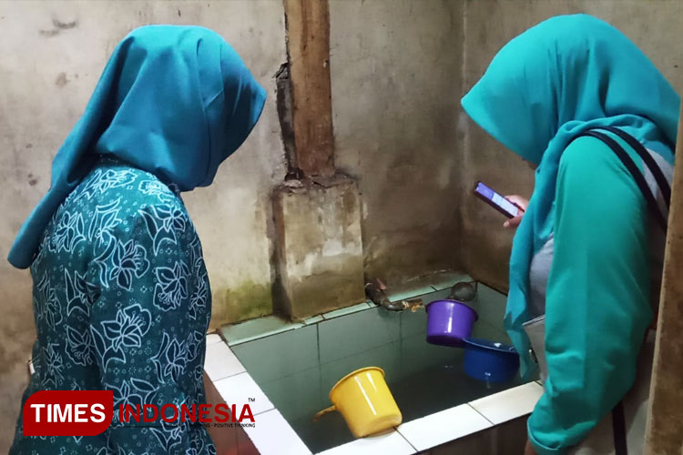 Petugas Puskesmas Kaliwates mengecek kondisi bak mandi di salah satu rumah warga. (FOTO: M. Abdul Basid/TIMES Indonesia)