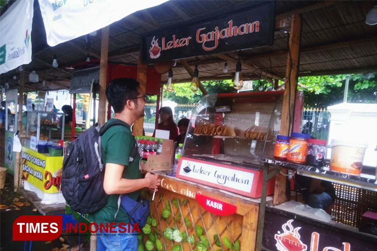 Salah satu pengunjung sedang membeli jajanan di Festival Makan-Makan Mangkunegaran. (FOTO: Anugrah Dany/TIMES Indonesia)
