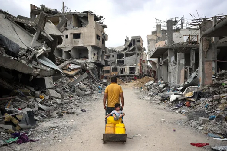 Seorang pria dan anak-anak Palestina melewati puing-puing bangunan yang hancur di Gaza. (FOTO: Al Jazeera/AFP).
