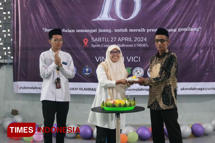 Pemotongan tumpeng oleh Ketua Umum UKM Olahraga diserahkan kepada pendamping UKM Olahraga Unisma Malang dalam Dies Natalis Ke – XVI di Sport Center and Ballrom UNISMA. (FOTO: AJP TIMES Indonesia)