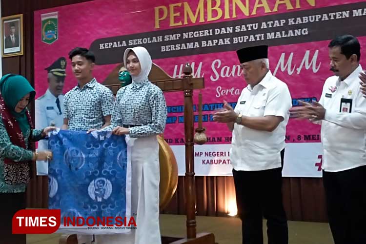Ketua Dekranasda Kabupaten Malang menyerahkan simbolis motif seragam batik Garudeya kepada perwakilan pelajar, saat acara Pembinaan MKKS SMP Negeri dan Satu Atap, di Kepanjen Kabupaten Malang, Rabu (8/5/2024). (Foto: Amin/TIMES Indonesia)