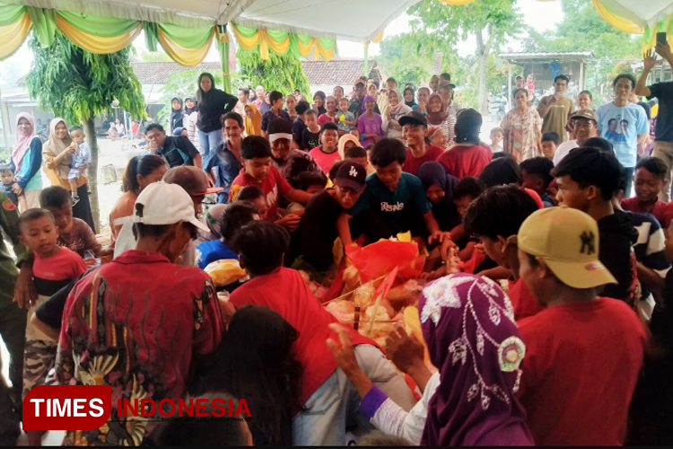 Suasana saling dorong dan berebut gunungan hasil panen raya dalam Tradisi Sedekah Bumi Dusun Guwo, Desa Manduro, Kabuh, Jombang. Kamis (9/5/2024). (FOTO: Bambang Cahyono/TIMES Indonesia)