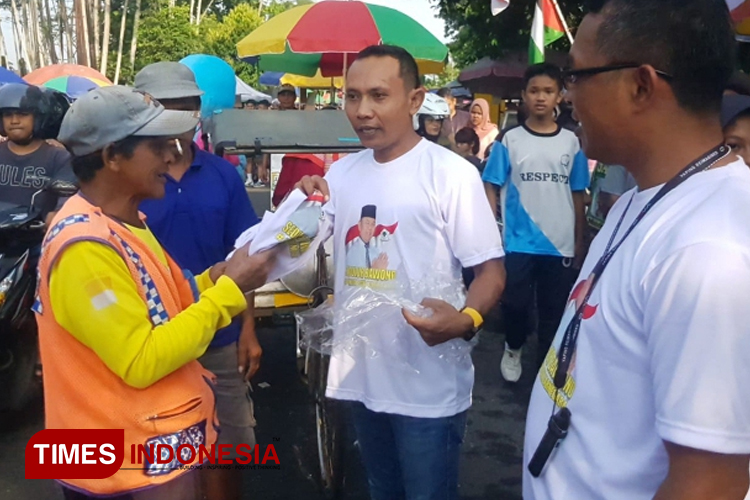Ketua Relawan Buwono, Sukijen bersama Untung dan relawan lain saat membagikan kaos kepada para pedagang Car Free Day dan juru parkir. (Foto: Muchlas Hamidi/TIMES Indonesia)