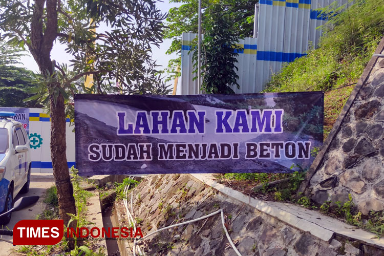 Baliho ungkapan protes warga terhadap salah satu Kontraktor PSN Bendung Bener, terpasang di pintu masuk akses jalan desa (Foto: Hery Priyantono/TIMES Indonesia)