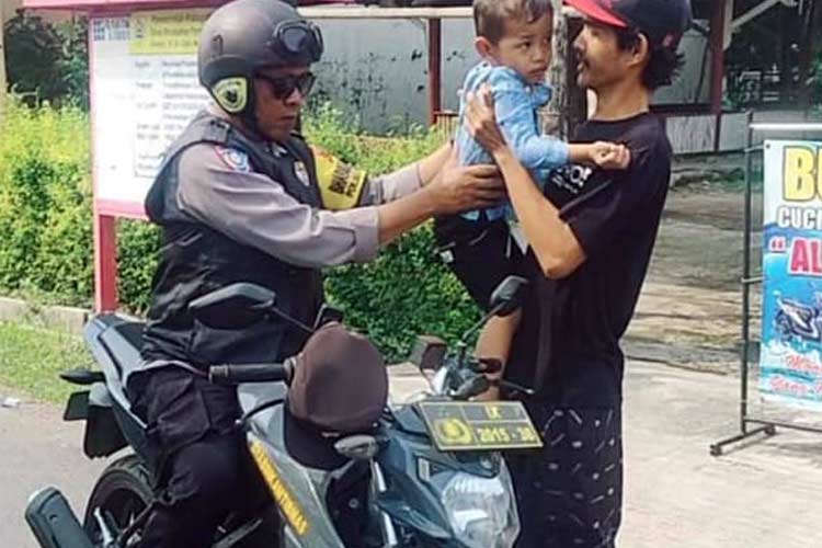 Balita yang sempat hilang karena bermain sendiri di kembalikan ke orangtuanya oleh anggota kepolisian (Foto: Ragil/TIMES Indonesia )