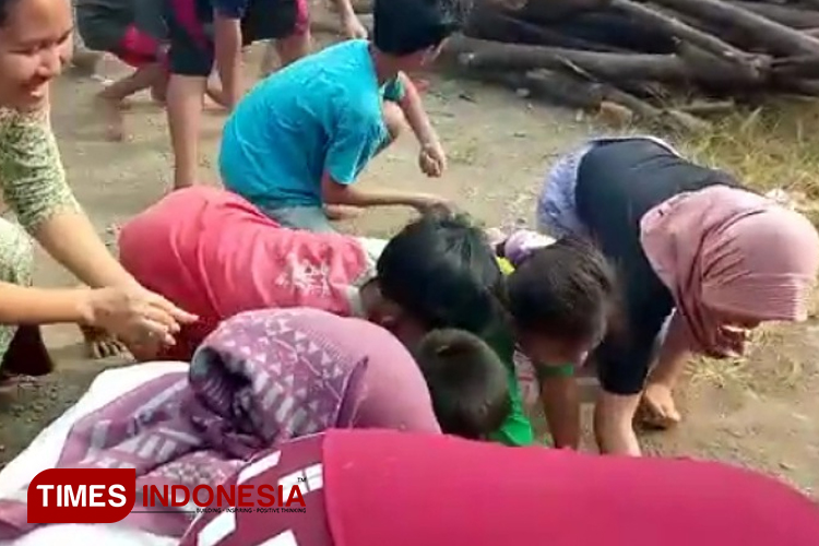Anak-anak dan orangtua berebut uang logam di acara tedak sithen. (Foto: Ragil/TIMES Indonesia)