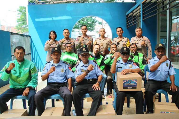 Pemberian bantuan oleh Satlantas Polresta Malang Kota dan Akpol kepada driver ojol. (Foto: Dok. Polresta Malang Kota)