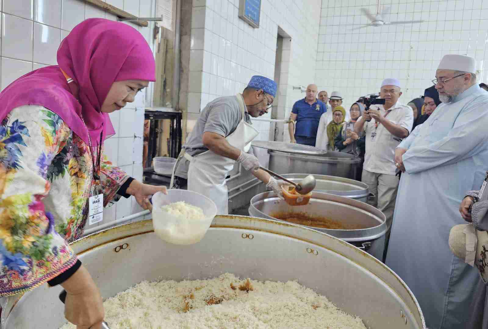 Ketum Muslimat Khofifah Indar Parawansa mengisi makanan yang akan dibagikan. (Foto: Muslimat NU for TIMES INDONESIA)