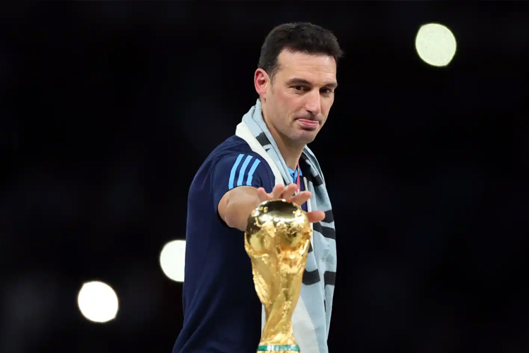 Pelatih Lionel Scaloni menyentuh trofi Piala Dunia yang dimenangkan Argentina di Qatar. (EFE)