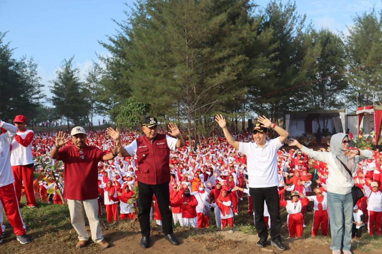 Bupati Malang HM Sanusi bersama ribuan peserta senam bersama lansia yang tampak seperti lautan merah putih, di Pantai Modangan, Kecamatan Donomulyo, Kabupaten Malang, Rabu (5/6/2024). (Foto: Humas Prokopim for TIMES Indonesia)