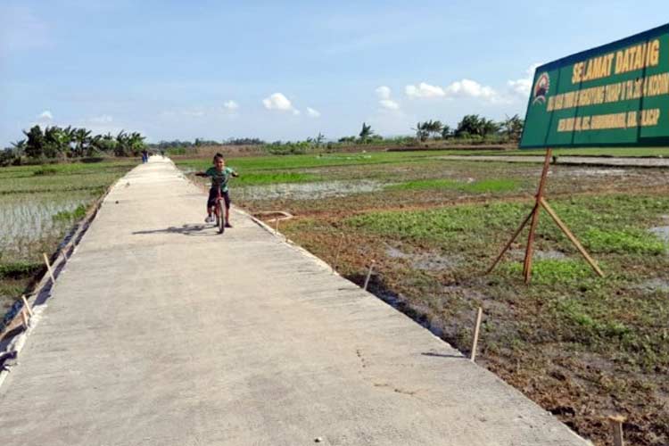 Aris sedang bermain sepeda di jalan baru hasil TMMD di Desa Bulusari, Gandrungmangu, Cilacap. (FOTO: Pendiam 0703 Cilacap for TIMES Indonesia)