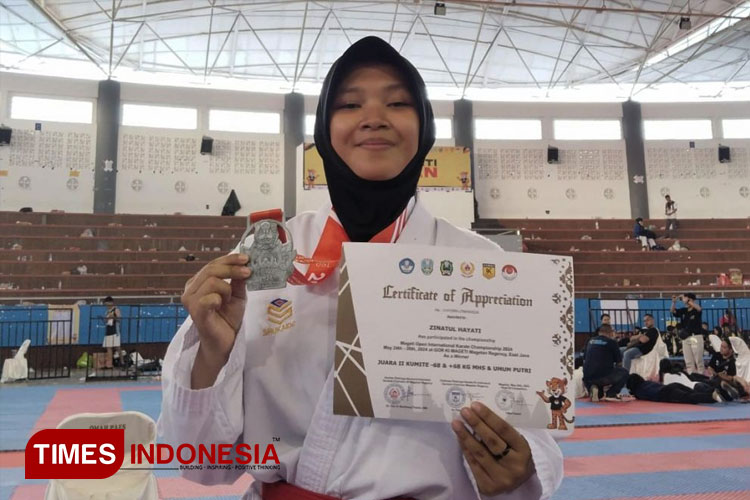 Zinayatul Hanati saat memegang medali dan sertifikat seusai penghargaan. (FOTO: AJP TIMES Indonesia)