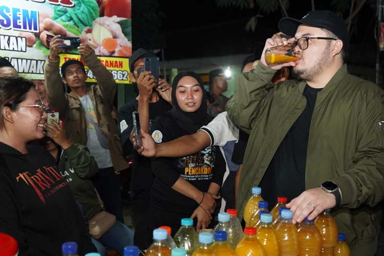 Bupati Kediri saat mencoba minuman jamu pelaku UMKM di acara pencak dor (Foto: Diskominfo Kabupaten Kediri)