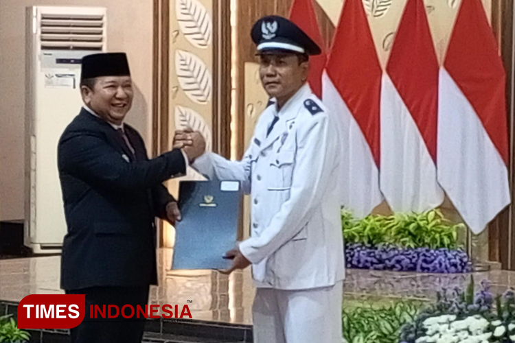 Bupati Jember Hendy Siswanto saat menyerahkan SK perpanjangan masa jabatan ke salah satu kades. (M. Abdul Basid/TIMES Indonesia)