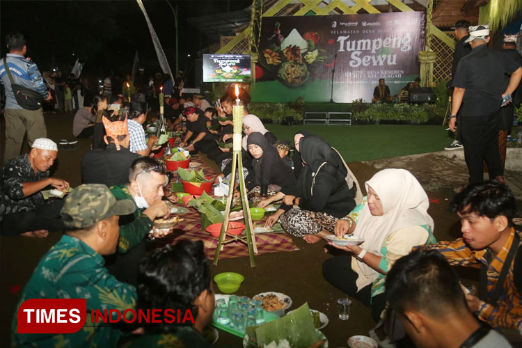 Para warga dan wisatawan sedang menikmati santapan tumpeng yang dilengkapi dengan pecel pithik dan sayur lalapan, lauk khas warga Kemiren pada ritual adat Tumpeng Sewu (FOTO: Humas Pemkab for TIMES Indonesia).