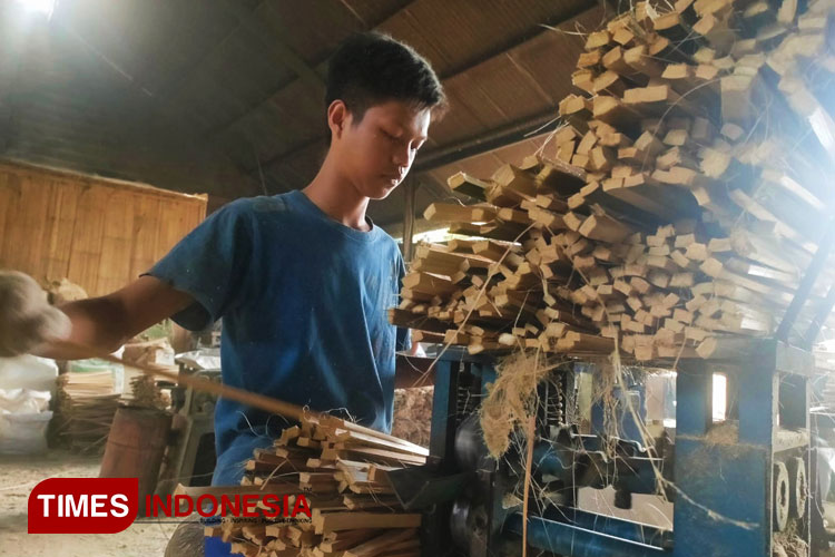 Seorang pekerja saat memasukan batangan bambu ke mesin bubut di rumah produksi di Kampung Panunggalan, Kelurahan Sukahurip, Kecamatan Tamansari, Kota Tasikmalaya, Jawa Barat. Kamis (13/6/2024). (FOTO: Harniwan Obech/TIMES Indonesia)
