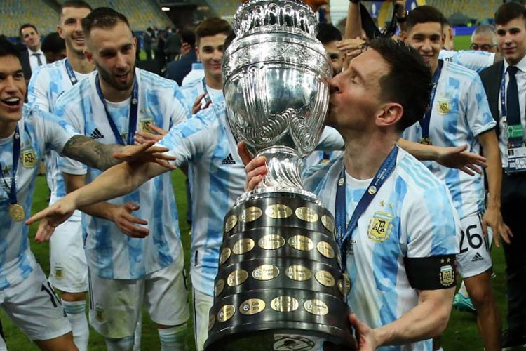 Kapten Timnas Argentina Lionel Messi mencium trofi Copa America. Argentina juara Copa America 2021 usai menang 1-0 atas Brasil. (Foto: psgtalk)