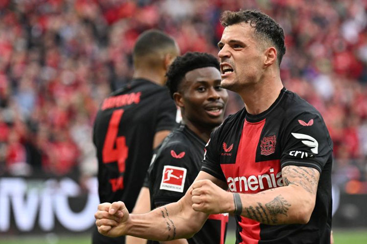 Gelandang Bayer Leverkusen asal Swiss Granit Xhaka melakukan selebrasi usai mencetak gol pada pertandingan Bundesliga melawan Werder Bremen di Leverkusen, 14 April 2024. (FOTO: AFP/INA FASSBENDER)