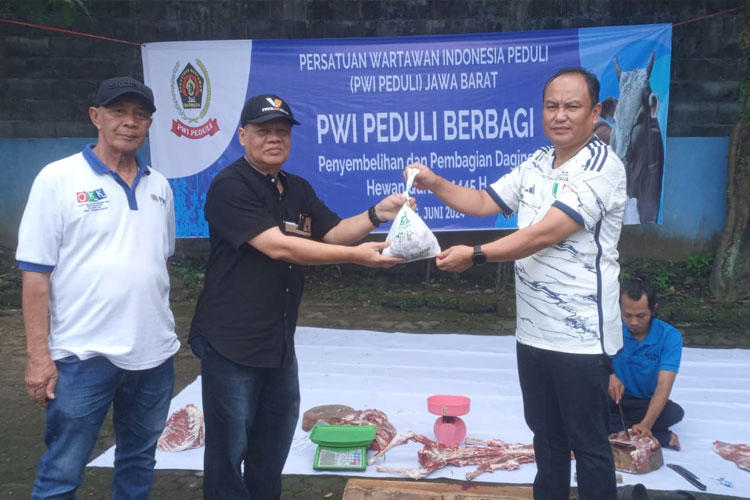 Penyerahan daging kurban secara simbolis oleh Ketua PWI Jabar Hilman Hidayat kepada untuk diserahkan kepada warga. (FOTO: Dok. PWI Jabar)
