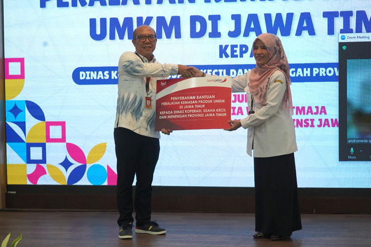 Direktur Mikro, Ritel, dan Menengah Bank Jatim R. Arief Wicaksono secara simbolis menyerahkan akses permodalan bagi UMKM melalui Kepala Bidang Produksi dan Restrukturisasi Usaha Diskop UKM Provinsi Jatim, Susanti Widyastuti, Rabu (19/6/2024) (FOTO: D
