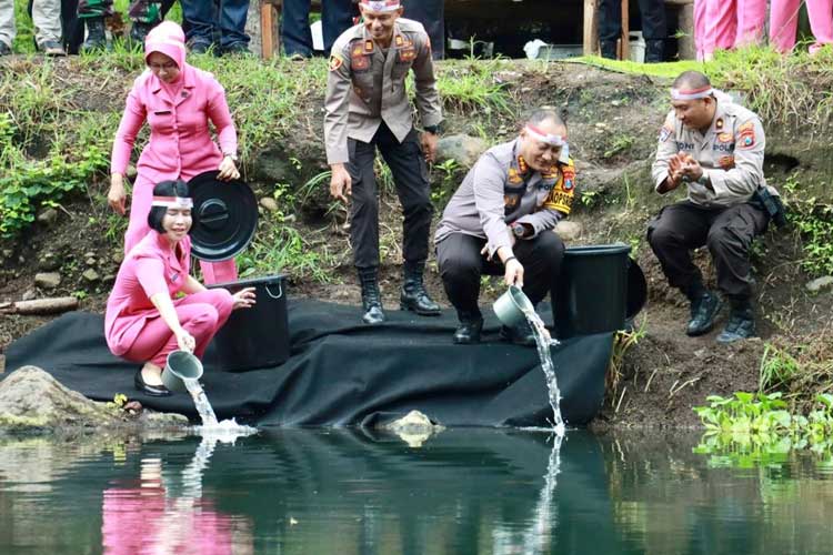 Kapolresta Banyuwangi, Kombes Pol Nanang Haryono, bersama sang istri, Nani Nanang Haryono, saat menebar ribuan bibit ikan di kolam pemancingan Kampung Jagong, Desa Wonosobo. (Foto: Dokumentasi TIMES Indonesia)