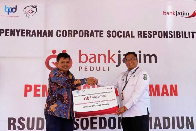 SEVP Korporasi, Sindikasi & Kelembagaan Bank Jatim Kurniawan Priambodo menyerahkan bantuan CSR kepada Direktur RSUD dr. Soedono Tauhid Islamy pada Rabu (26/6/2024). (FOTO: Dok. Humas Bank Jatim)