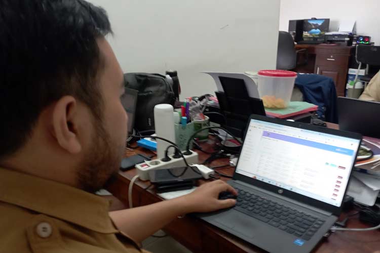 Petugas operator SIAK pelayanan permohonan dokumen adminduk Dinas Kependudukan dan Catatan Sipil Kabupaten Malang, saat mengecek permohonan dan verifikasi sebelum permohononan dokumen disetujui dan diterbitkan, Selasa (9/7/2024).