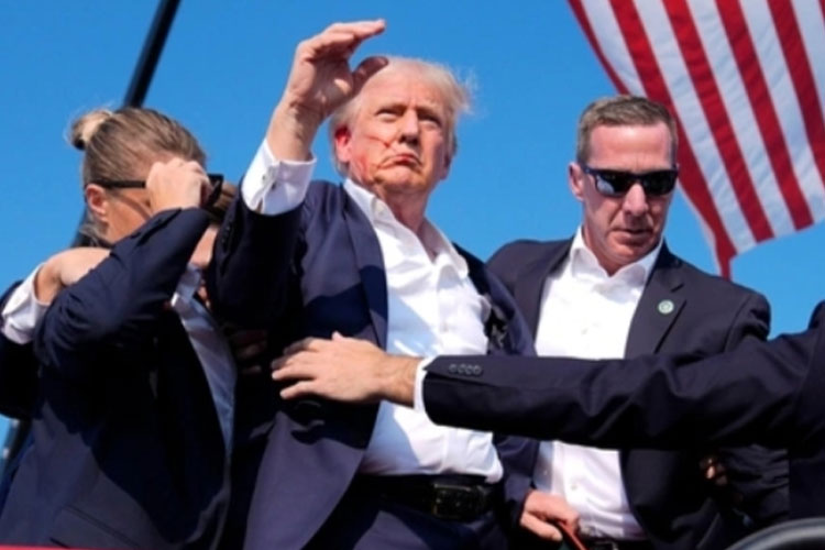 Trump dengan muka berdarah saat dievakuasi petugas Secret Service saat kampanye di Butler, Pensylvania, Sabtu. (Foto: AP Photo via VoA)