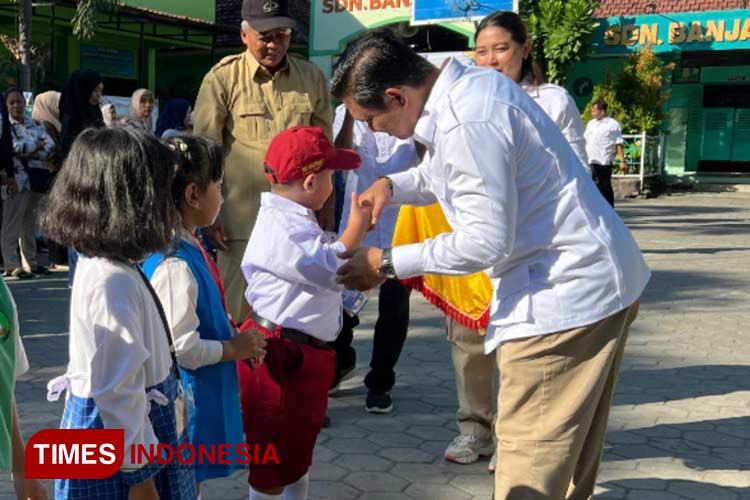 Wakil Ketua DPRD Kota Kediri Katino saat memberikan roti dan susu pada salah satu murid sekolah dasar (foto : yobby/Times Indonesia)