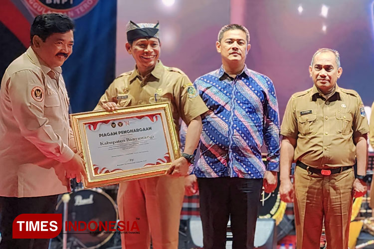 Menko Polhukam RI, Marsekal TNI (Purn) Hadi Tjahjanto, SIP, menyerahkan piagam penghargaan kepada Plt. Kepala Bakesbangpol Banyuwangi, Drs R Agus Mulyono MSi. (Foto: Fazar Dimas/TIMES Indonesia)