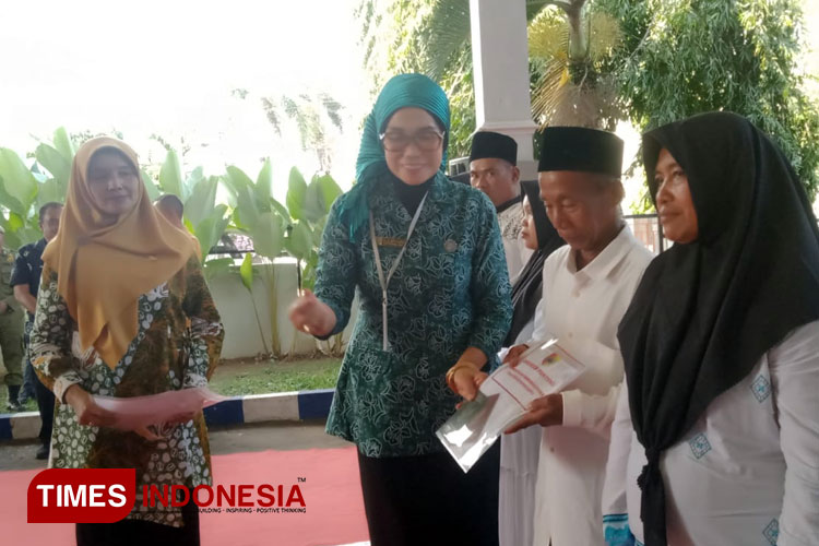 Kepala Dispendukcapil Jember membagikan dokumen kependudukan kepada masyarakat. (M. Abdul Basid/TIMES Indonesia)
