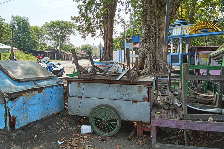 Tumpukan Material Pedagang seperti gerobak, meja kursi dan terpal pedagang nampak berserakan di depan pintu masuk obyek wisata Pantai Widuri Pemalang. (FOTO: Ragil).
