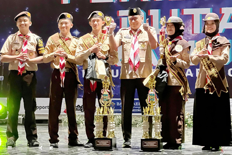 Mukti Cahyo Kusuma dan Nadia Hafidz Az-Zahra berfoto bersama Ketua Kwarcab Karanganyar, Kurniadi Maulato, pada malam penganugerahan Pemilihan Duta Pramuka Karanganyar 2024, Sabtu (20/7/2024). (dok Duta Pramuka Karanganyar 2024)