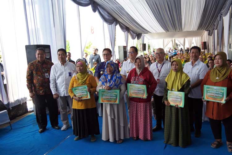 Pj Gubernur Jatim Adhy Karyono serta Direktur Mikro, Ritel, dan Menengah Bank Jatim R. Arief Wicaksono saat penyerahan BLT DBHCHT 2024 kepada buruh pabrik rokok lintas wilayah di Koperasi Kareb Unit SKT MPS Kapas Bojonegoro, Jumat (19/7/2024).