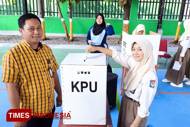 Ketua KPU Magetan, Noviano Suyide saat mendampingi pemilih pemula dari SMA Negeri 1 Magetan saat melakukan simulasi pencoblosan dibilik suara. (Foto: Aditya Candra/TIMES Indonesia)