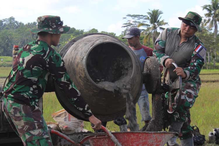 Dua personel TNI saat mengoperasikan mesin molen cor di Desa Pangliaran, Pancatengah, Kabupaten Tasikmalaya. Kamis (25/7/2024) (FOTO: Pen Kodim 0612/Tasikmalaya)