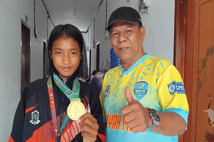 Novenjel alias Angel, siswa SMP Desa Bido Morut penyumbang medali emas pertama, foto bersama Asisten II Pemkab Morotai, Syafruddin Manyila. (Foto: Irwanto for TIMES Indonesia).