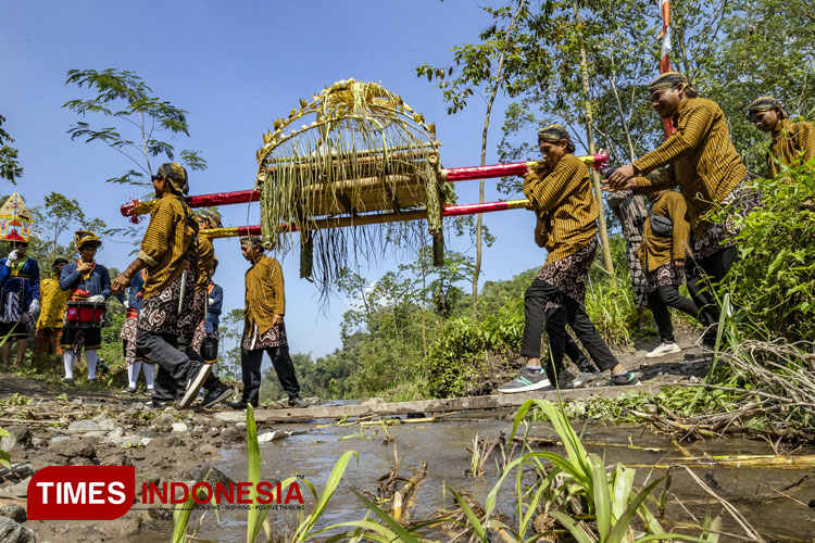 Kirab Tumpeng yang digotong warga menyeberangi Kali Boyong menuju Umbul Boyong. (Foto: Eko Susanto/TIMES Indonesia)