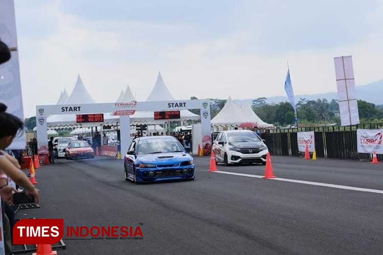 Dua mobil tengah beradu cepat dilintasan lurus di sirkuit non permanen Lanud Wiriadinata, Kota Tasikmalaya, Minggu (28/7/2024). (FOTO: Harniwan Obech/TIMES Indonesia)