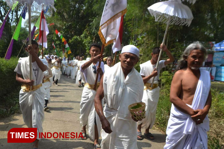 Pembawa payung pengapit kauman berada di barisan depan, diikuti oleh para perempuan yang membawa Kendi berisi air yang diambil dari sembilan mata air. (FOTO: Catur Arif/ TIMES Indonesia)