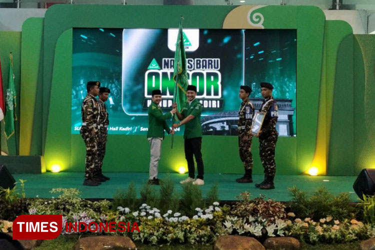 Penyerahan bendera dari Ketua GP Ansor sebelumnya Rizmi Haitami Azizi kepada M Kanzul Fikri (foto : yobby/Times Indonesia)