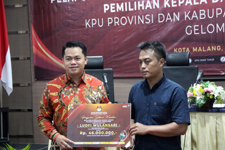 Ketua KPU Jatim Aang Kunaifi saat menyerahkan santunan kepada ahli waris Pantarlih yang meninggal dunia, Senin (29/7/2024) kemarin. (Foto: Dok. KPU Jatim)