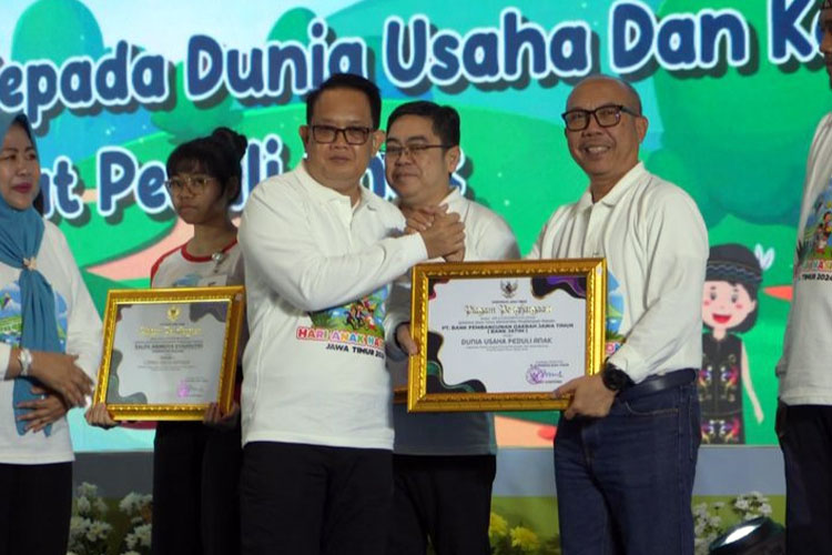 Pj Gubernur Jawa Timur Adhy Karyono saat memberikan penghargaan kepada Direktur Mikro, Ritel & Menengah Bank Jatim R. Arief Wicaksono pada Jumat (26/7/2024).(Foto: Dok.Humas Pemprov Jatim)