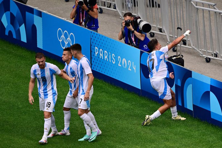 Pemain Argentina Giuliano Simeone melakukan selebrasi atas gol kedua yang diciptakan gelandang Claudio Echeverri ke gawang Ukraina di penyisihan grup B Olimpiade Paris 2024 di Lyon Stadium, Lyon, Selasa (30/7/2024). (Photo by Olivier CHASSIGNOLE/AFP)