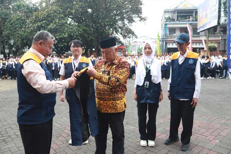 Rektor Universitas PGRI Kanjuruhan Malang, Dr. Sudi Dul Aji, M.Si., saat mengenakan rompi kepada Bupati Malang, HM Sanusi, sebelum pelepasan peserta KKN Unikama 2024, di lapangan Rektorat Unikama, Kamis (1/8/2024). (Foto: Humas Pemkab)