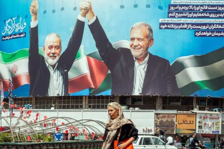 Papan iklan di Teheran dengan foto Ismail Haniyeh dan Presiden Iran yang baru, Masoud Pezeshkian. (FOTO: The New York Times)